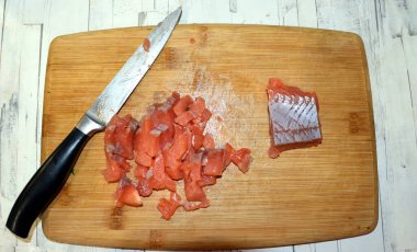 Kesme tahtasında bıçak ve bir parça kırmızı balık.