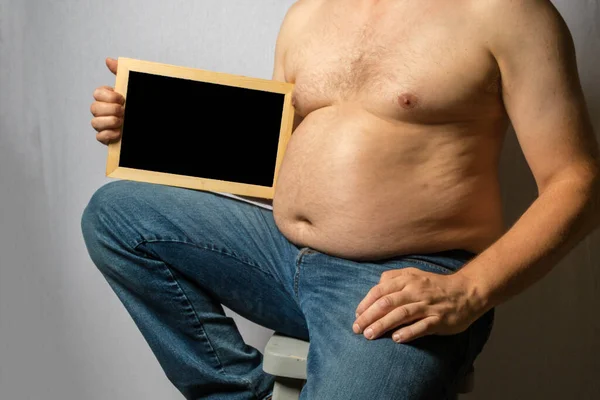 Overweight Shirtless Caucasian Man Sitting Holding Blackboard — Stockfoto