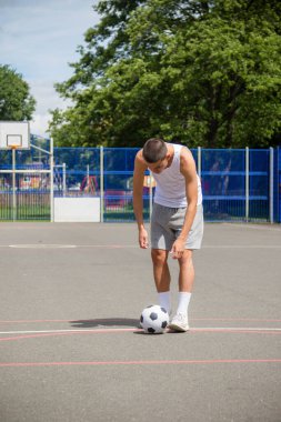 Halka açık bir parkta futbol oynayan 19 yaşında bir genç çocuk.