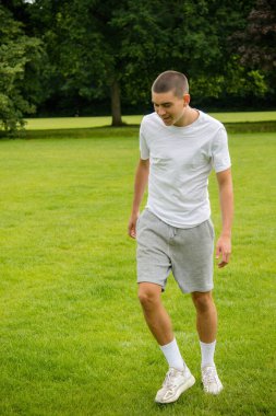 Halka açık bir parkta futbol oynayan 19 yaşında bir genç çocuk.