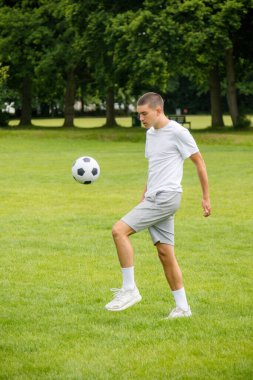 Halka açık bir parkta futbol oynayan 19 yaşında bir genç çocuk.
