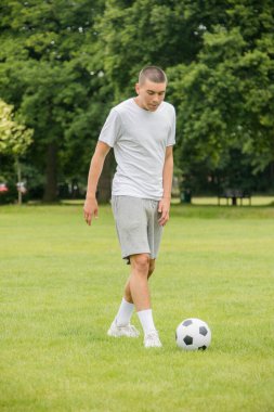 Halka açık bir parkta futbol oynayan 19 yaşında bir genç çocuk.
