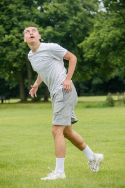 Halka açık bir parkta futbol oynayan 19 yaşında bir genç çocuk.