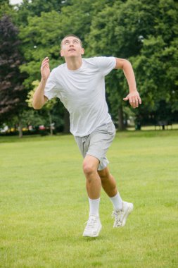 Halka açık bir parkta futbol oynayan 19 yaşında bir genç çocuk.