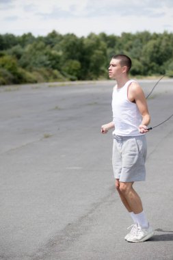 Halk parkında ip atlayan 19 yaşında bir genç çocuk.