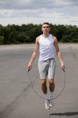 Halk parkında ip atlayan 19 yaşında bir genç çocuk.