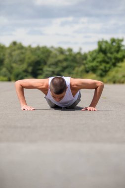 Halka açık bir parkta şınav çeken 19 yaşında bir çocuk.