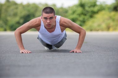A Nineteen Year Old Teenage Boy Doing Push Ups A Public Park