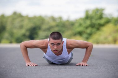 A Nineteen Year Old Teenage Boy Doing Push Ups A Public Park