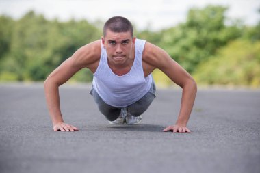 Halka açık bir parkta şınav çeken 19 yaşında bir çocuk.