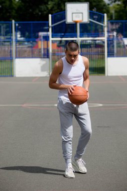 A Nineteen Year Old Teenage Boy Shooting A Hoop in A Basketball Court in A Public Park