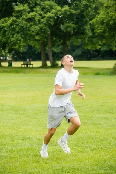 Halka açık bir parkta futbol oynayan 19 yaşında bir genç çocuk.