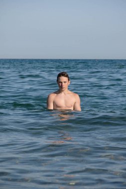 A 17 Year Old Teenage Boy Walking Out Of The Sea