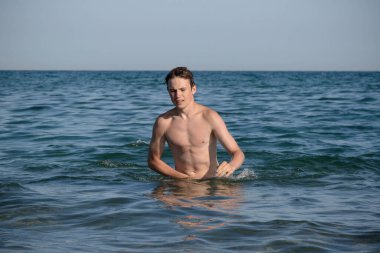A 17 Year Old Teenage Boy Walking Out Of The Sea