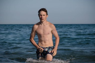 A 17 Year Old Teenage Boy Walking Out Of The Sea