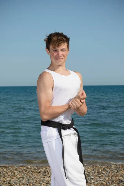 A 17 Year Old Teenage Black Belt Flexing His Muscles on A Beach