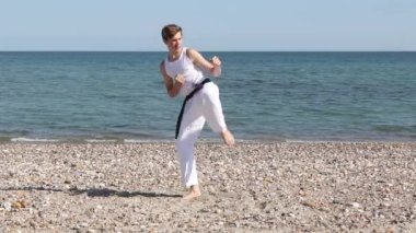 Teenage Boy Doing Karate Kicks on A Beach