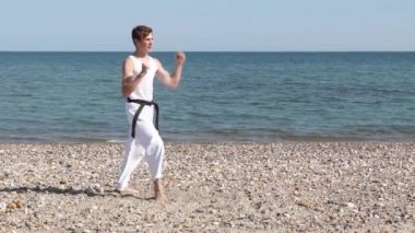 Teenage Boy Doing Karate Kicks on A Beach