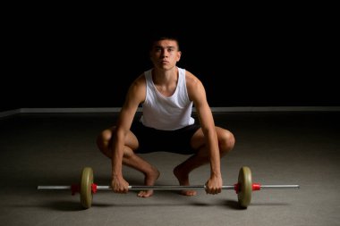 19 yaşındaki genç bir çocuk bir halter kaldırıyor.
