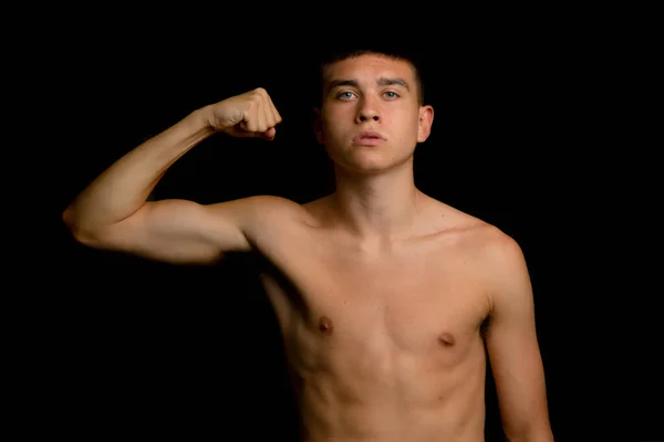 Shirtless Adolescent Ans Fléchissant Ses Muscles Bras Sur Fond Noir — Photo