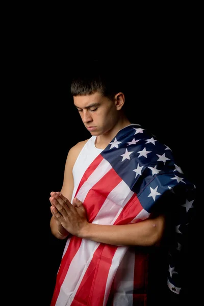 Portrét Devatenáctiletého Chlapce Černém Pozadí Americkou Vlajkou Modlící — Stock fotografie