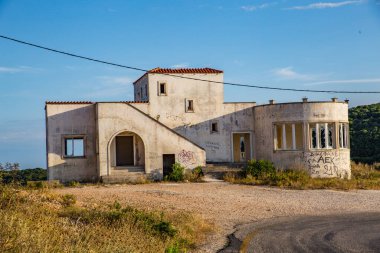 Korfu Yunanistan adasında camları kırık ve duvarları boyalı terk edilmiş bir ev.