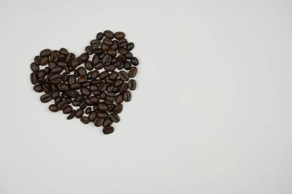 San Valentín foto del día un corazón romántico en el amor montado a partir de granos de café en la superficie —  Fotos de Stock