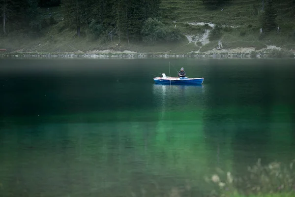 El concepto de un estilo de vida saludable es respirar aire fresco y limpio de la montaña y disfrutar de la pureza y el color azul del agua mientras se sienta en un barco en los lagos mágicos de las montañas alpinas de —  Fotos de Stock