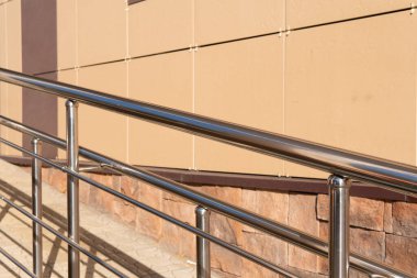 Engelliler için rampadaki çelik parmaklıklar. Engelli insanlara yardım etme kavramı..