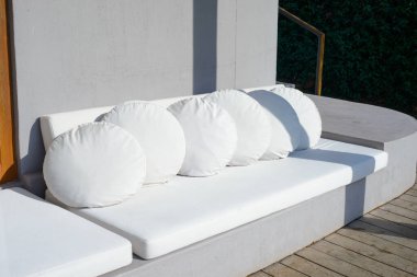 Açık hava duvarı. Gri duvarın önündeki beyaz kanepe.