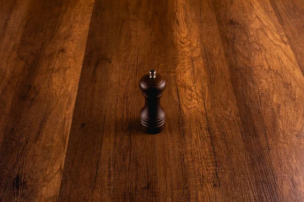 Ahşap arka planda biberli ahşap biber öğütücü.