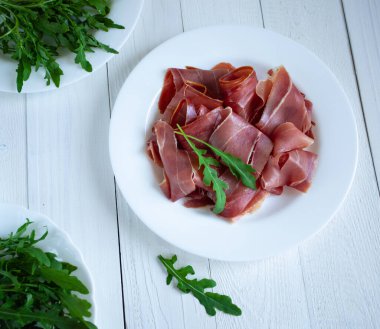 Beyaz arkaplanda jamonlu plaka, yakın plan.