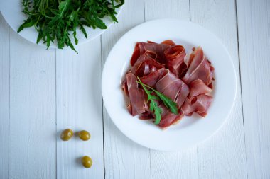 Beyaz arkaplanda jamonlu plaka, yakın plan.