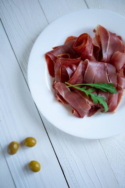 Beyaz arkaplanda jamonlu plaka, yakın plan.