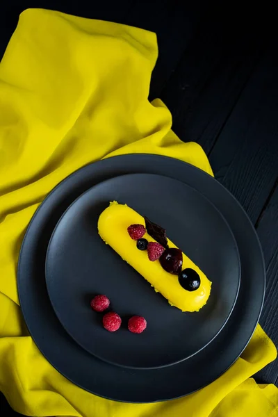 Lezzetli ve renkli kekler ve siyah arka planda taze çilekler..