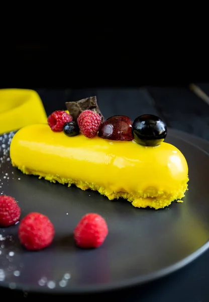 Lezzetli ve renkli kekler ve siyah arka planda taze çilekler..