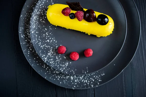 Lezzetli ve renkli kekler ve siyah arka planda taze çilekler..