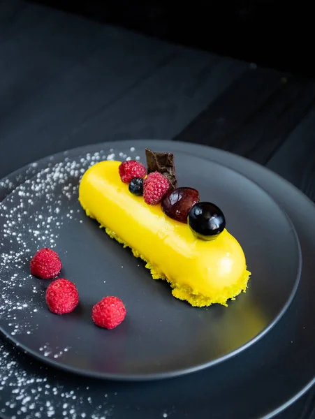 Lezzetli ve renkli kekler ve siyah arka planda taze çilekler..