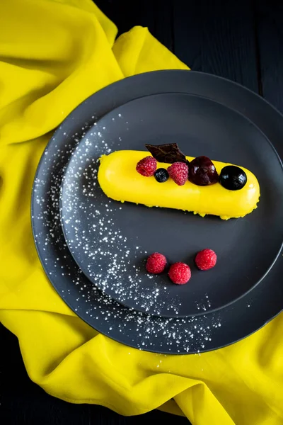 Lezzetli ve renkli kekler ve siyah arka planda taze çilekler..