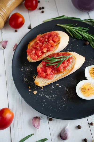 Domatesli bruschetta ve ahşap arka planda fesleğen. en üstteki görünüm.