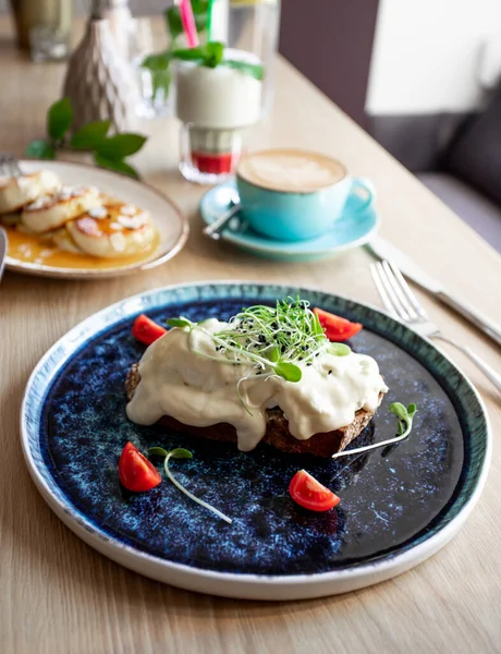 Avokadolu kahvaltı tostu, haşlanmış yumurta ve otlar.