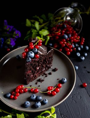 Böğürtlenli çikolatalı pasta ve siyah arkaplanda nane.