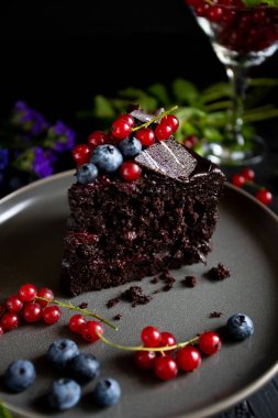 Böğürtlenli çikolatalı pasta ve siyah arkaplanda nane.