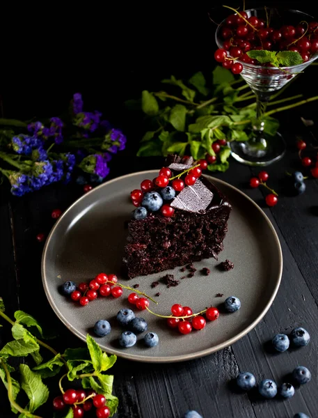 Koyu arka planda ev yapımı çikolatalı kekler. siyah frenk üzümü.