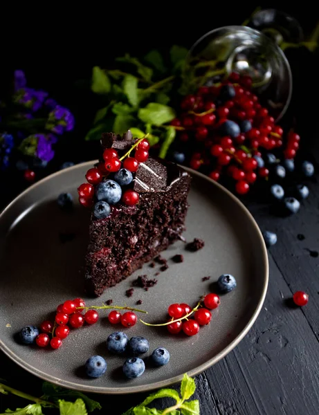 Böğürtlenli çikolatalı pasta ve siyah arkaplanda nane.