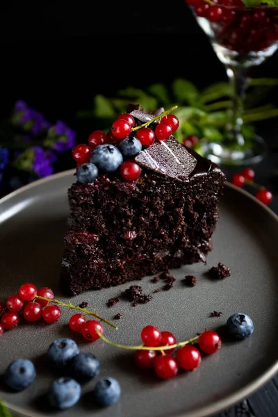 Böğürtlenli çikolatalı pasta ve siyah arkaplanda nane.