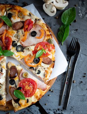 Göğüs eti, sosis, domates ve zeytinli pizza.