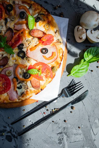 Göğüs eti, sosis, domates ve zeytinli pizza.