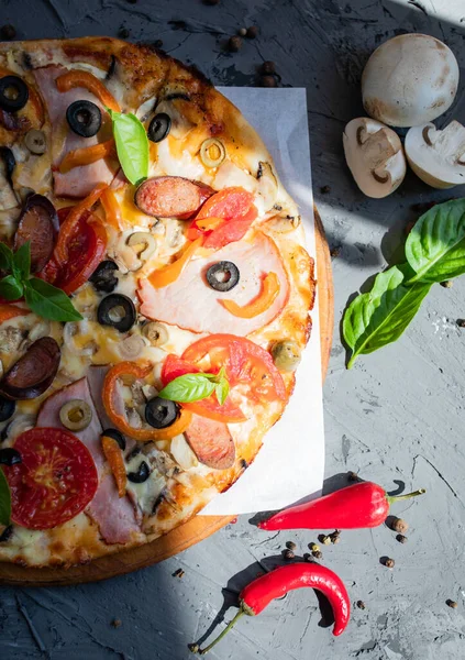 Göğüs eti, sosis, domates ve zeytinli pizza.