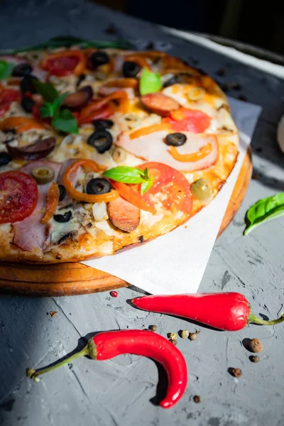 Göğüs eti, sosis, domates ve zeytinli pizza.